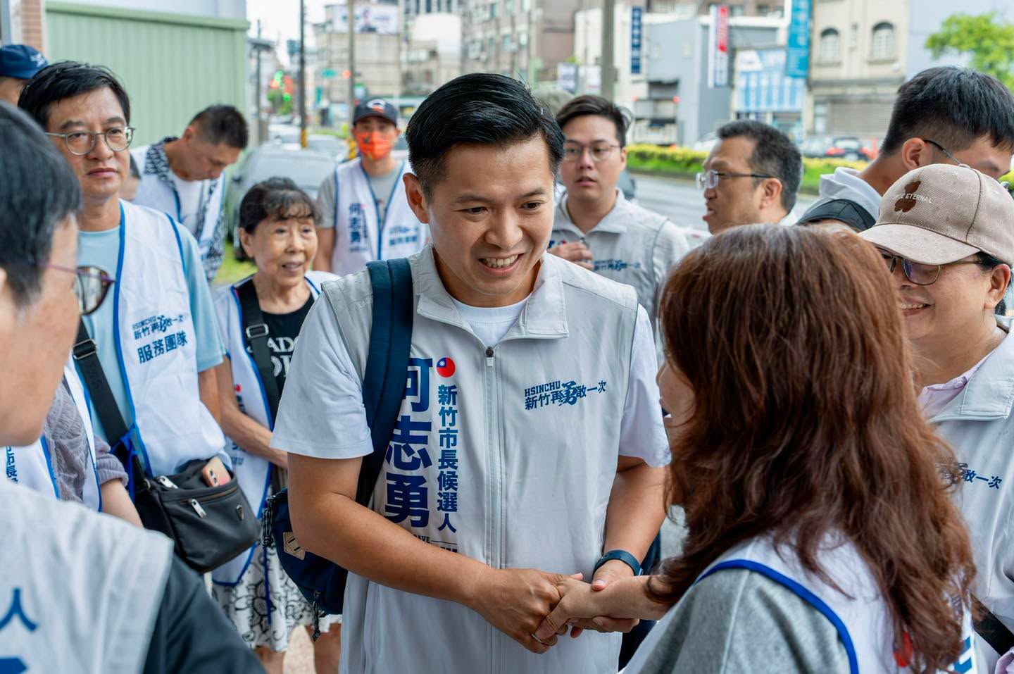 何志勇登記參選當天於街頭與支持者握手致意